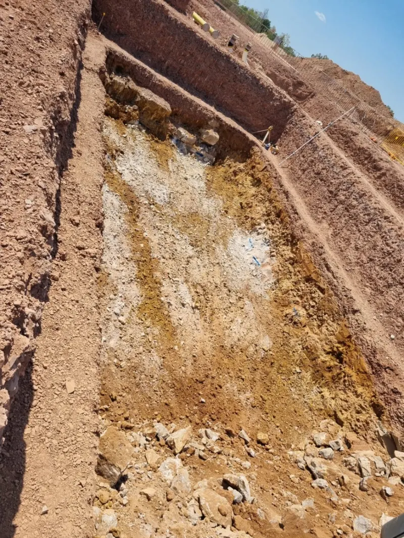 Benched rock face excavated to design batter