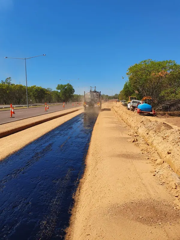 Bitumen sprayer applying primer seal to widened highway shoulder