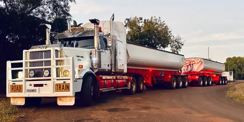 Road train side tippers at dusk