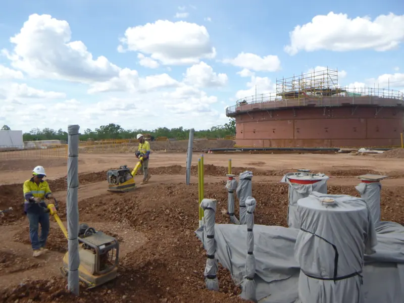 Labour crew running plate compactors around tank foundation services