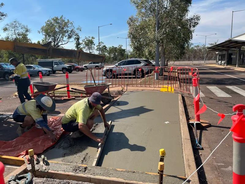 Crew screeding a new concrete footpath crossing