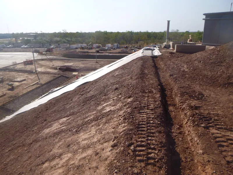 Embankment liner and drain run along a trimmed batter