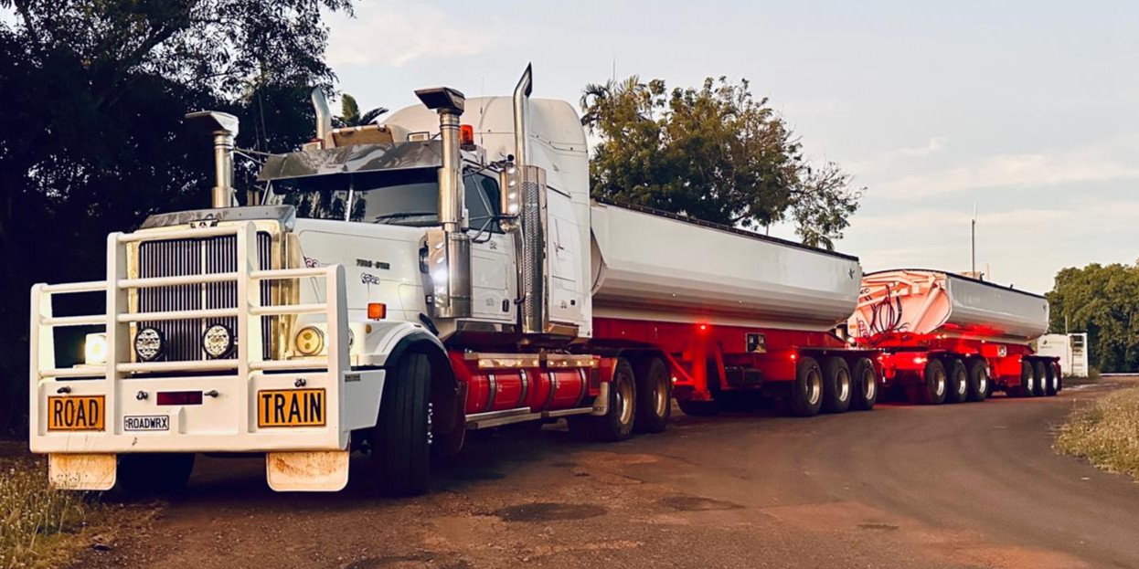 Wombarra Civil Construction road train with side tipper trailers at dusk