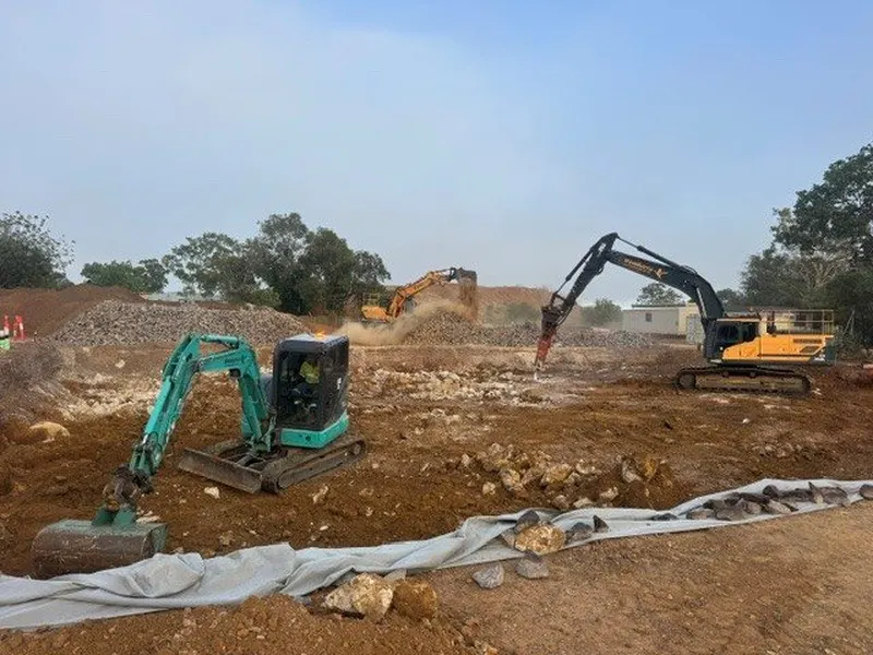 Excavators and rock breaker clearing a rocky site