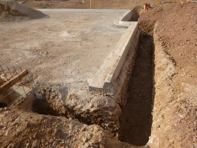 Deep services trench excavated behind a new concrete kerb