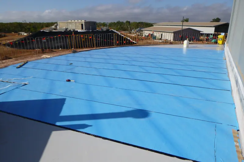 Blue waterproofing membrane sheets laid across large deck slab