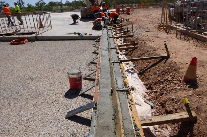 Crew forming and pouring a concrete slab edge