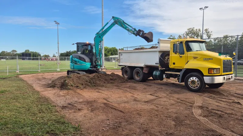 Excavator loading a tipper truck during road formation works