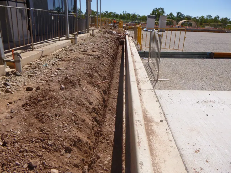 Conduit trench excavated around a building perimeter