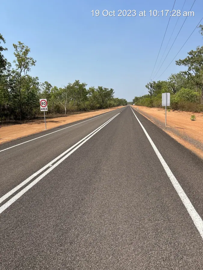 Completed sealed highway with fresh line marking through NT bushland