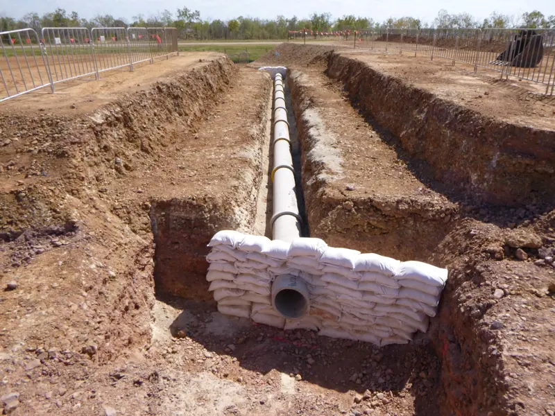 Pipeline trench with sandbag headwall at the outlet
