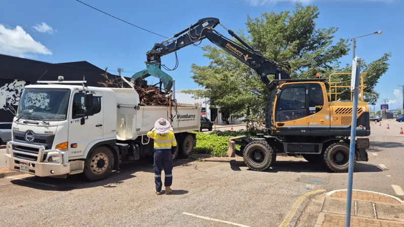 Wombarra grab excavator loading green waste into a tipper truck