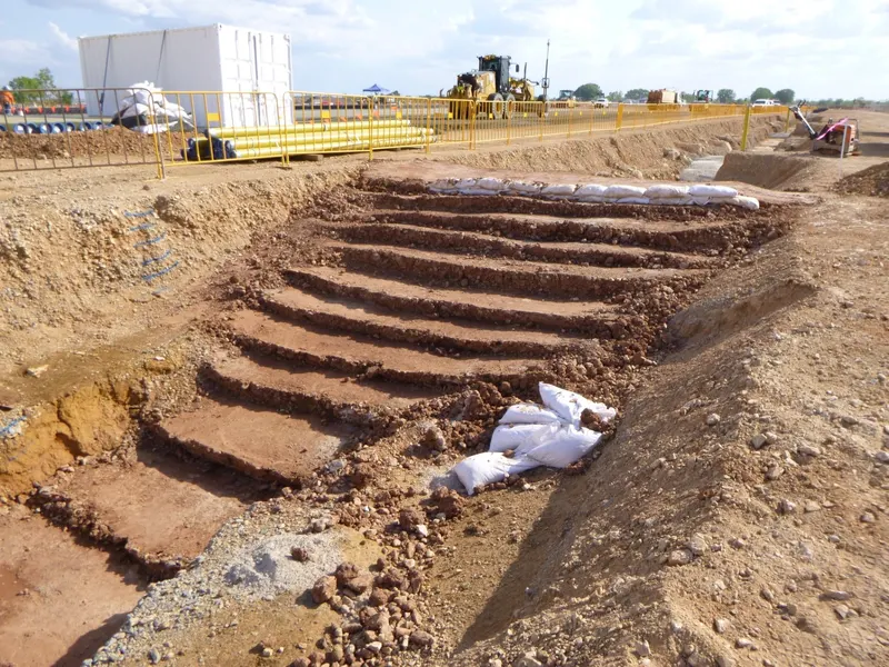 Benched batter excavation with sandbag erosion checks