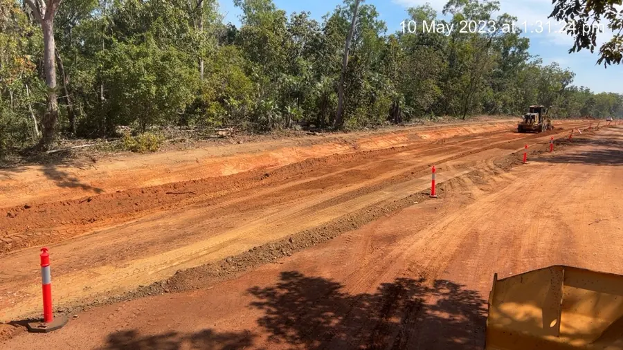 Grader widening a rural road formation with delineators in place