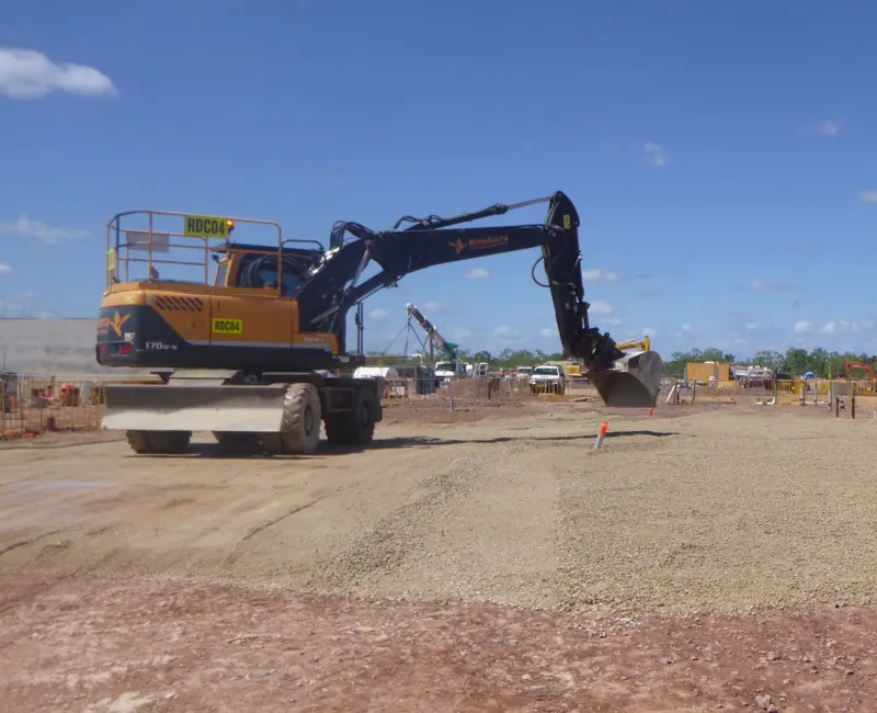 Wombarra wheeled excavator trimming gravel hardstand on hire