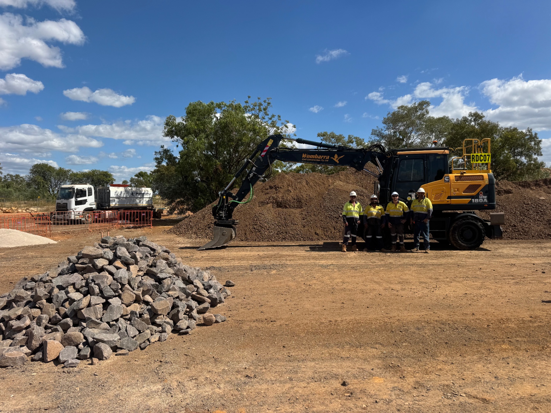 Wombarra Civil Construction crew with branded excavator on a Northern Territory project