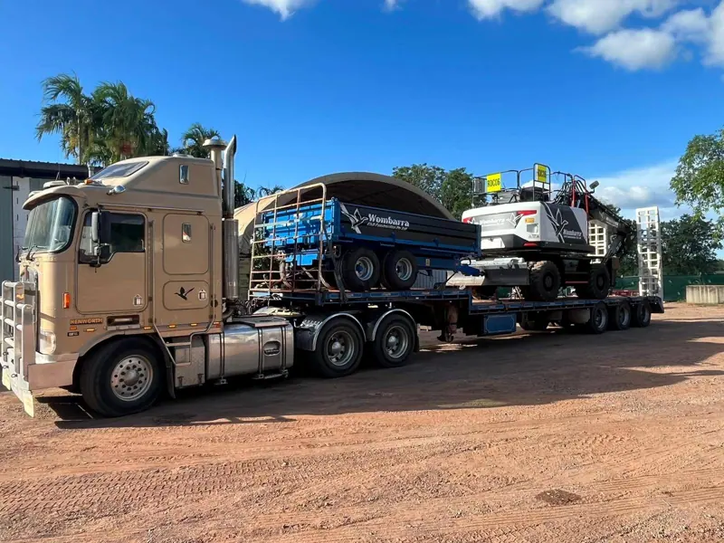 Kenworth float carrying wheeled excavator and tipper body